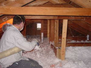 Blown-in insulation being installed in crawl space.